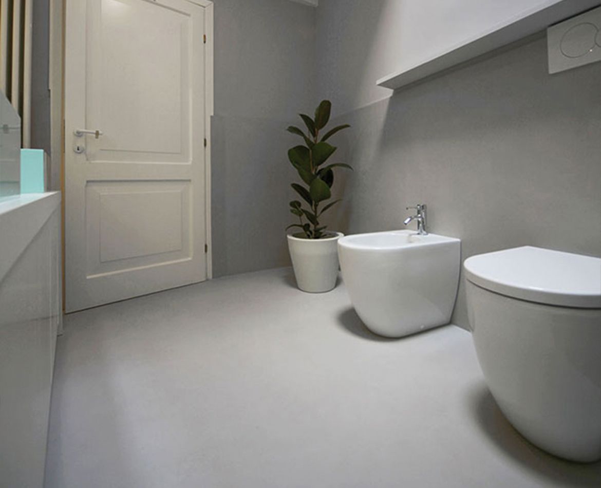 Pareti e pavimento in resina grigia per bagno minimale