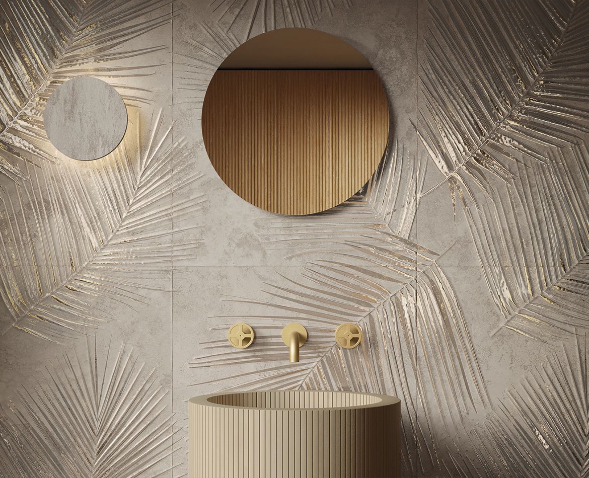 Parete bagno con foglie incise e finiture oro su fondo materico