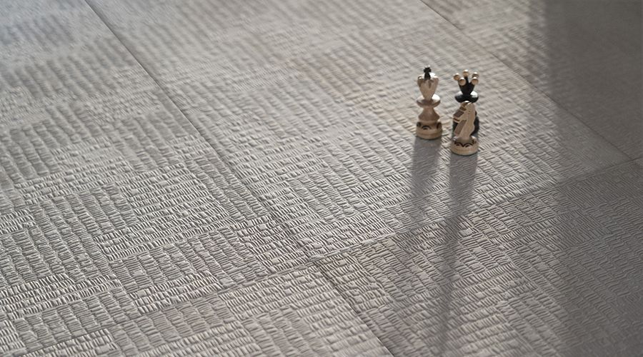 Pavimento materico effetto tessuto con pedine degli scacchi