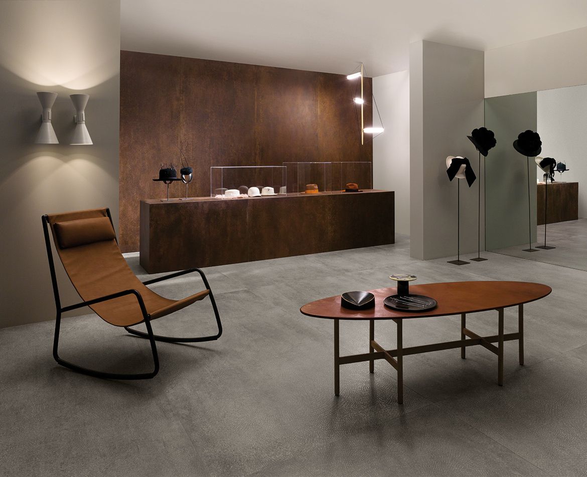 Showroom moderno con rivestimenti effetto corten e pavimento in grès grigio