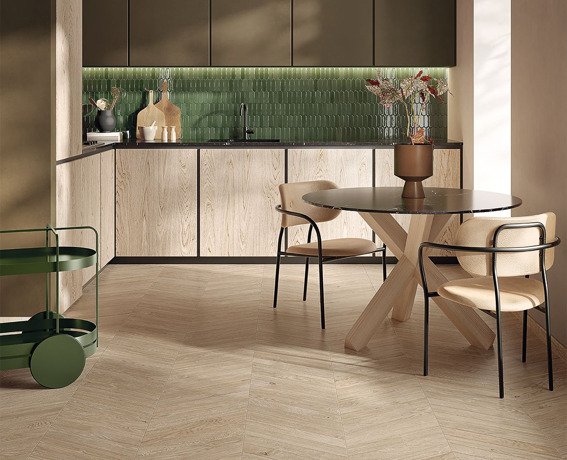 Cucina luminosa con rivestimento verde lucido e pavimento effetto rovere chiaro