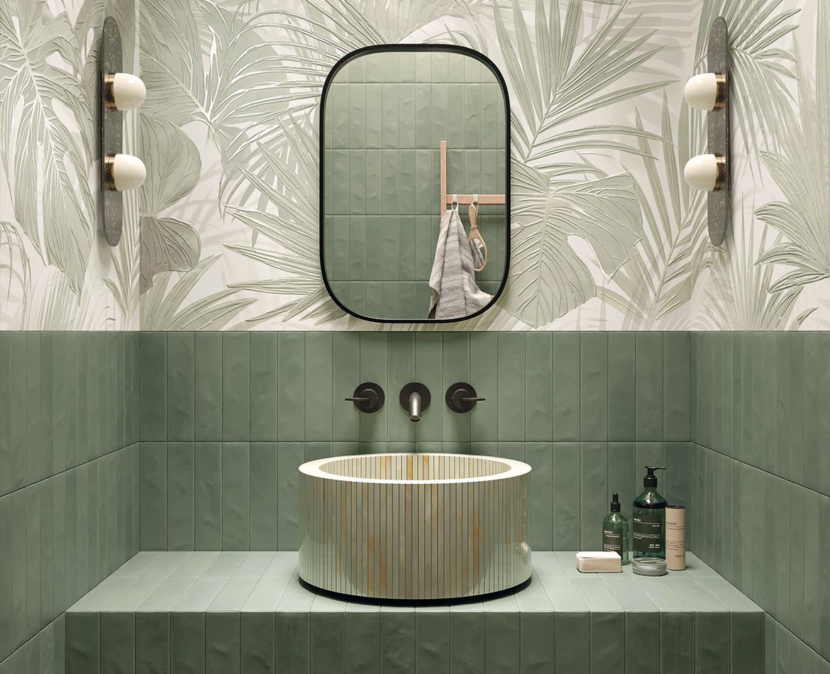 Rivestimento verde con decoro tropicale e lavabo cilindrico